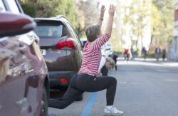 Eine Bewohnerin des Laenggassquartiers turnt auf der Strasse, waehrend einem improvisierten Fitnesstraining, am Samstag, 4. April 2020 in Bern. (KEYSTONE/Peter Klaunzer)